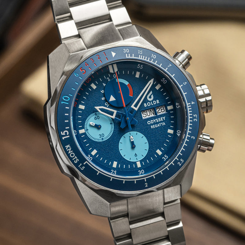 Close-up of a BOLDR Odyssey Regatta watch with a blue dial and stainless steel bracelet.