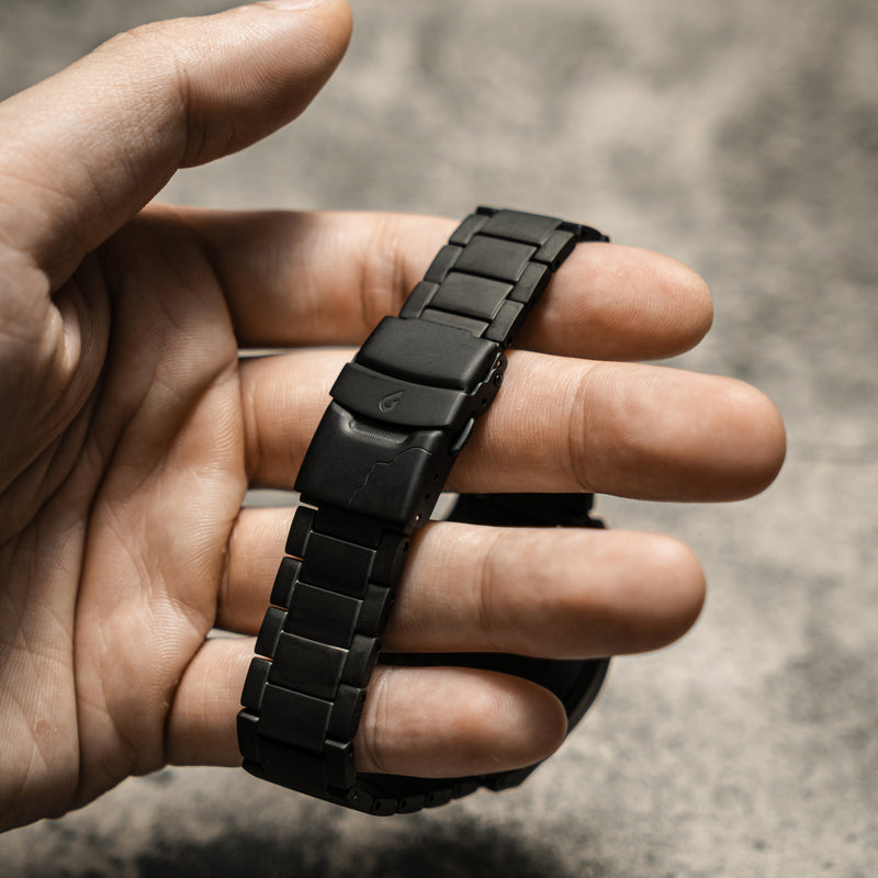 Black bracelet and buckle displayed on a palm