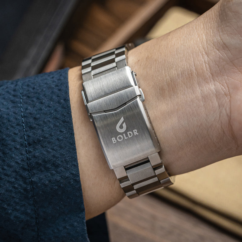 Close-up of a BOLDR Odyssey Regatta watch with a blue dial and stainless steel bracelet.