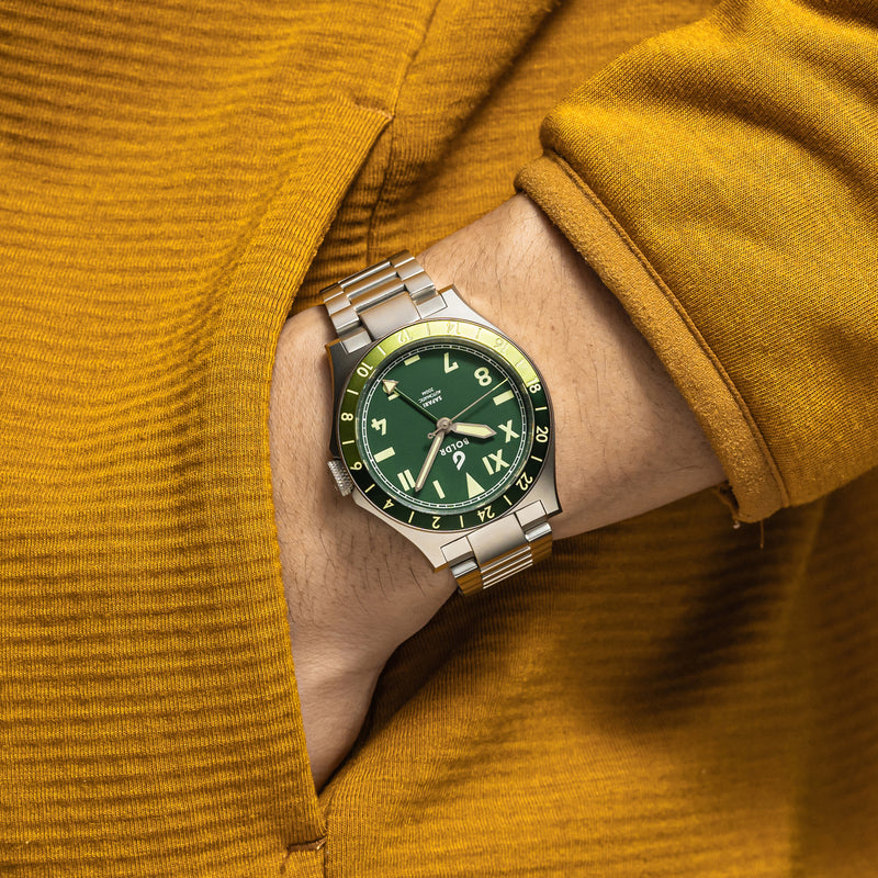 BOLDR Safari watch with a green dial, Roman and Arabic numerals, and a stainless steel bracelet.