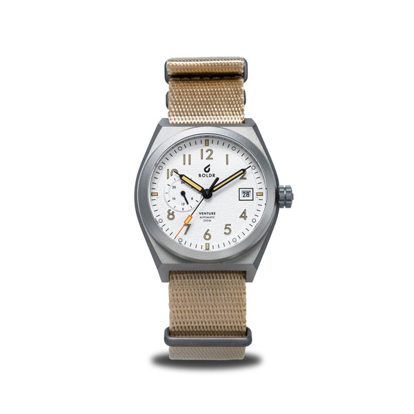 BOLDR automatic watch with a beige fabric strap and a silver bezel, featuring a textured silver dial with beige and orange accents.